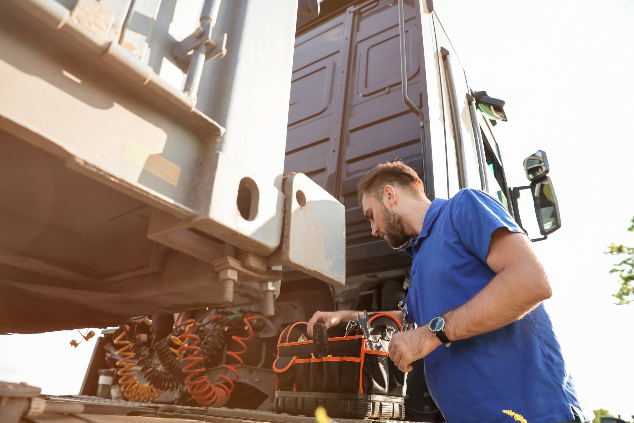 Male Driver Repairing Big Truck Outdoors